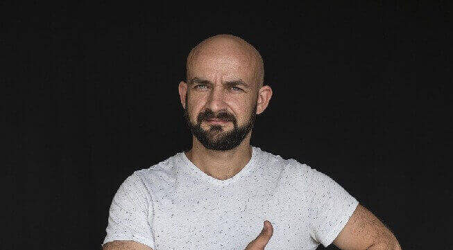 um cliente careca de olhos azuis e com barba e bigode